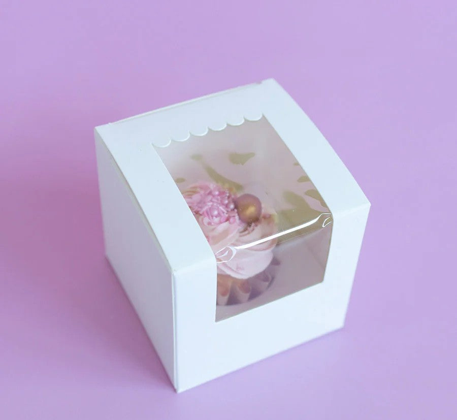White cake box with a clear window on a pink background