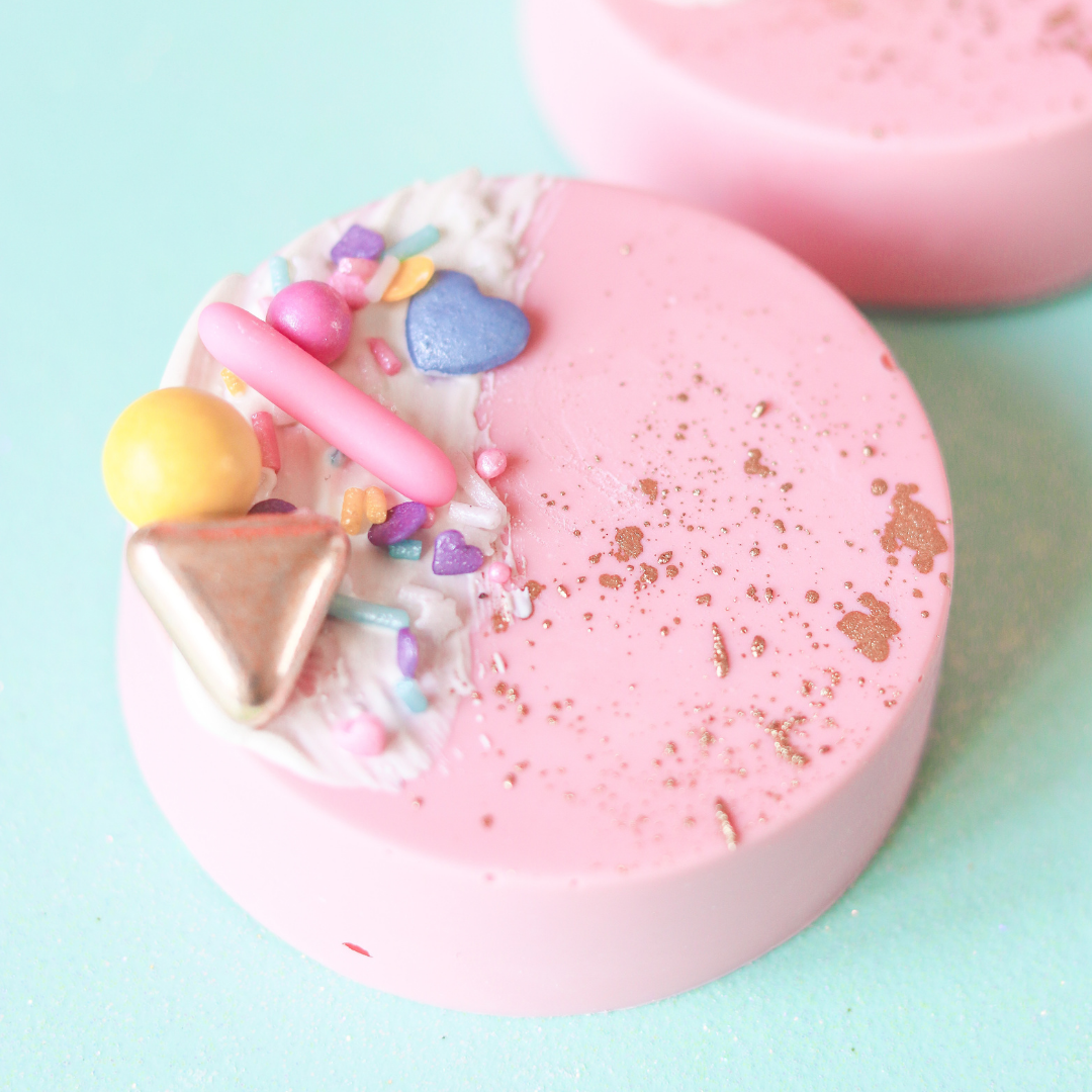 Pink chocolate with colorful toppings on a light blue background