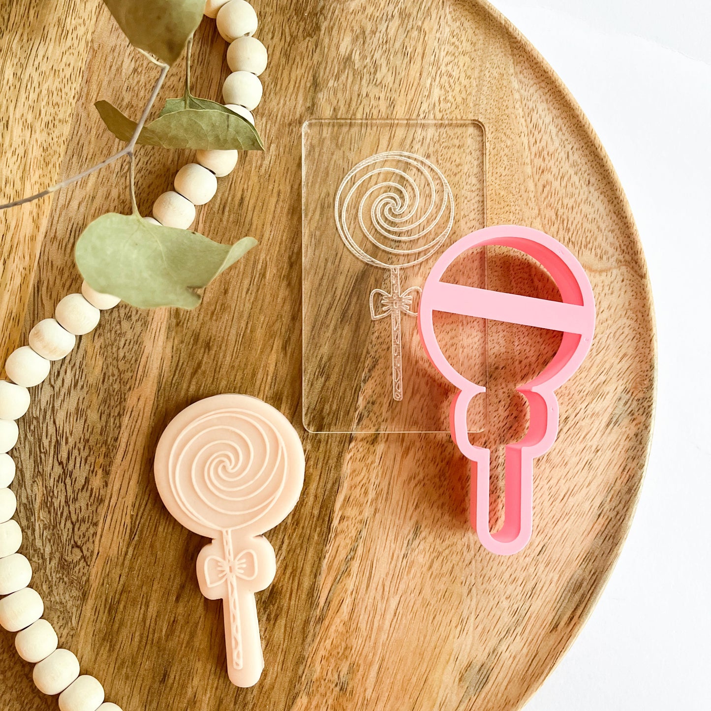 Lollipop-shaped cookie cutter and bow embosser, great for decorating cookies for birthday parties or candy-themed celebrations.