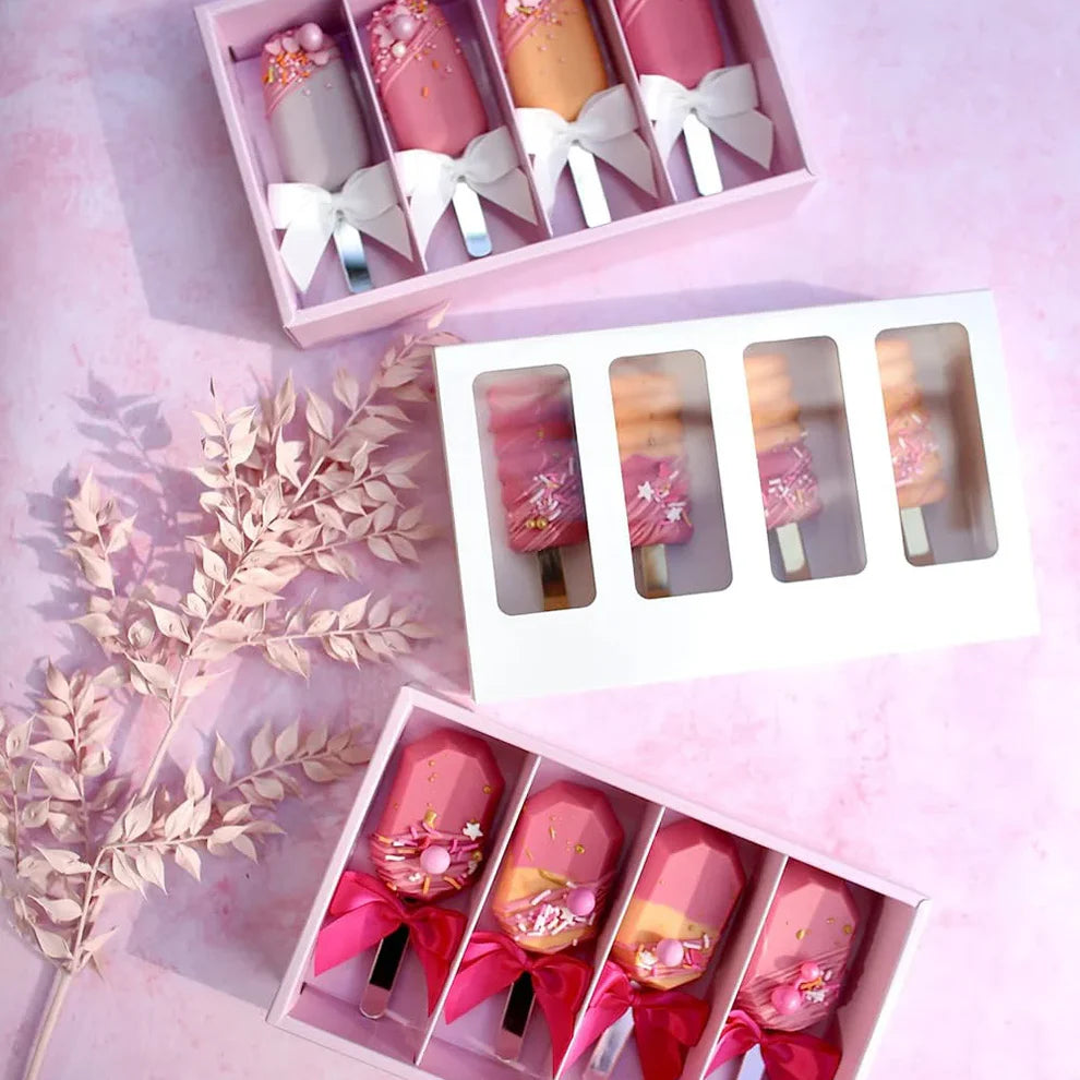 Set of pink lipsticks with decorative packaging on a pink background