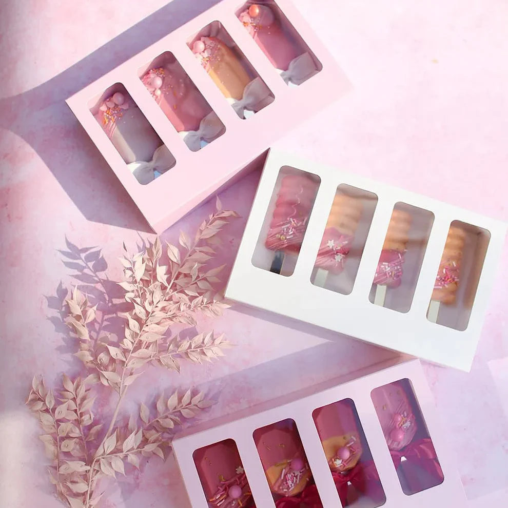 Set of lip glosses in a decorative box with a soft pink background