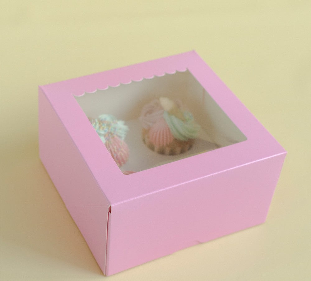 Pink gift box with a small pink and green toy inside on a light yellow background
