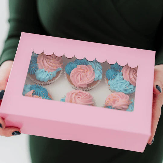 Pink box with cupcake design held by a person