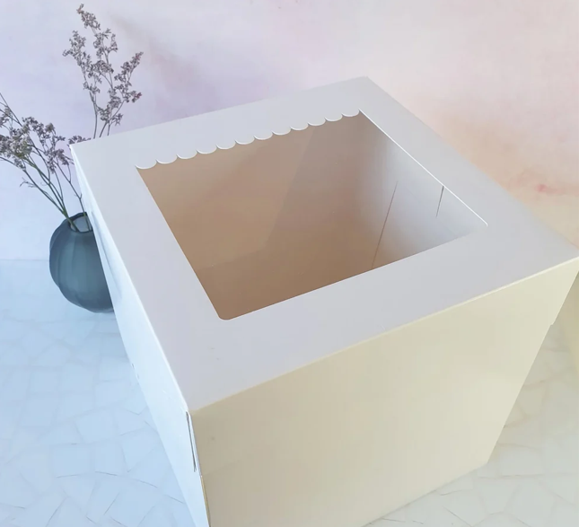 White cake box with a scalloped edge on a light background