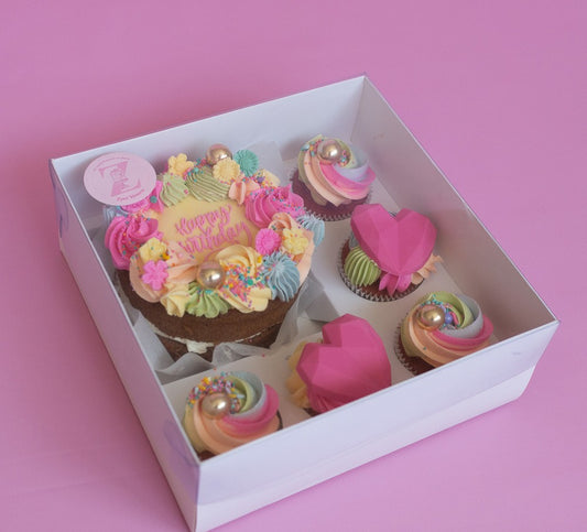 Box of cupcakes with a 'Happy Birthday' cupcake on a pink background