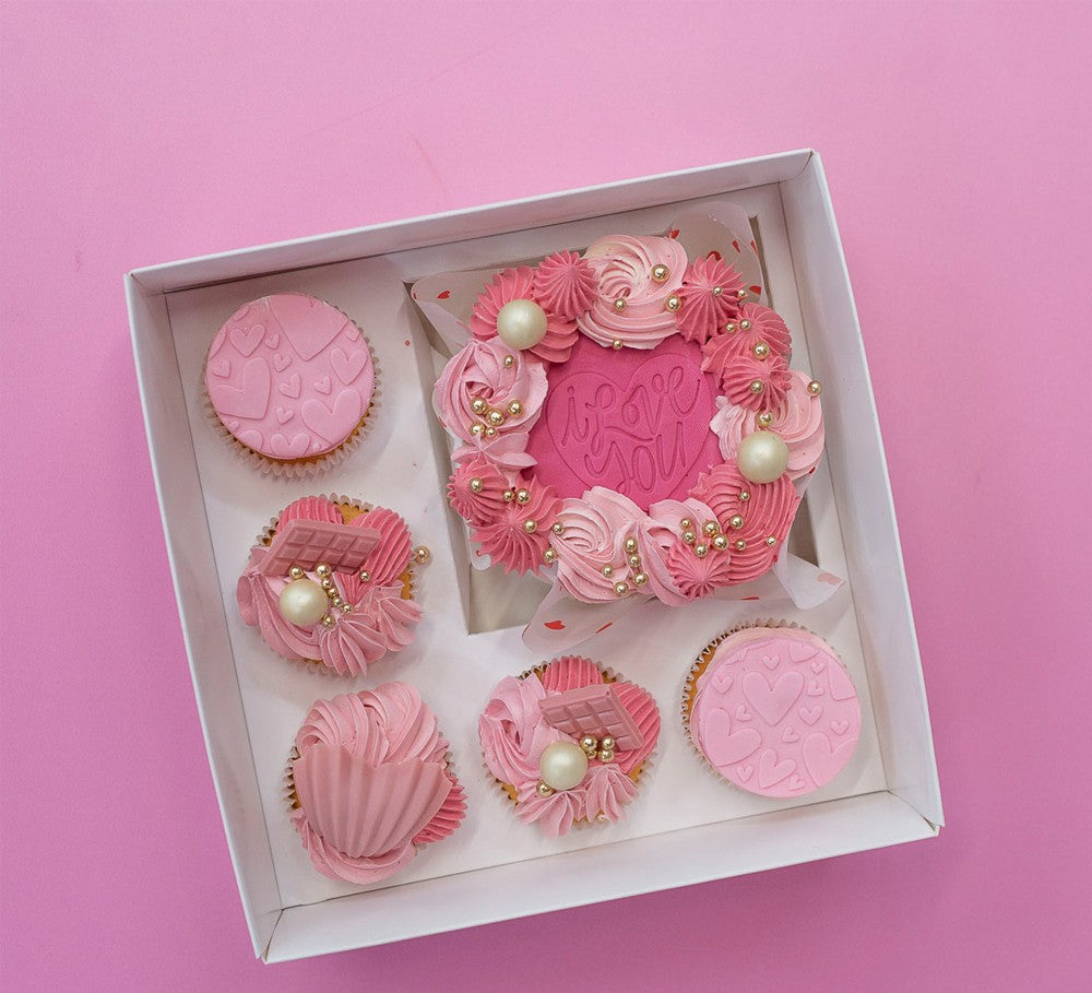 Decorative pink cupcakes in a box on a pink background