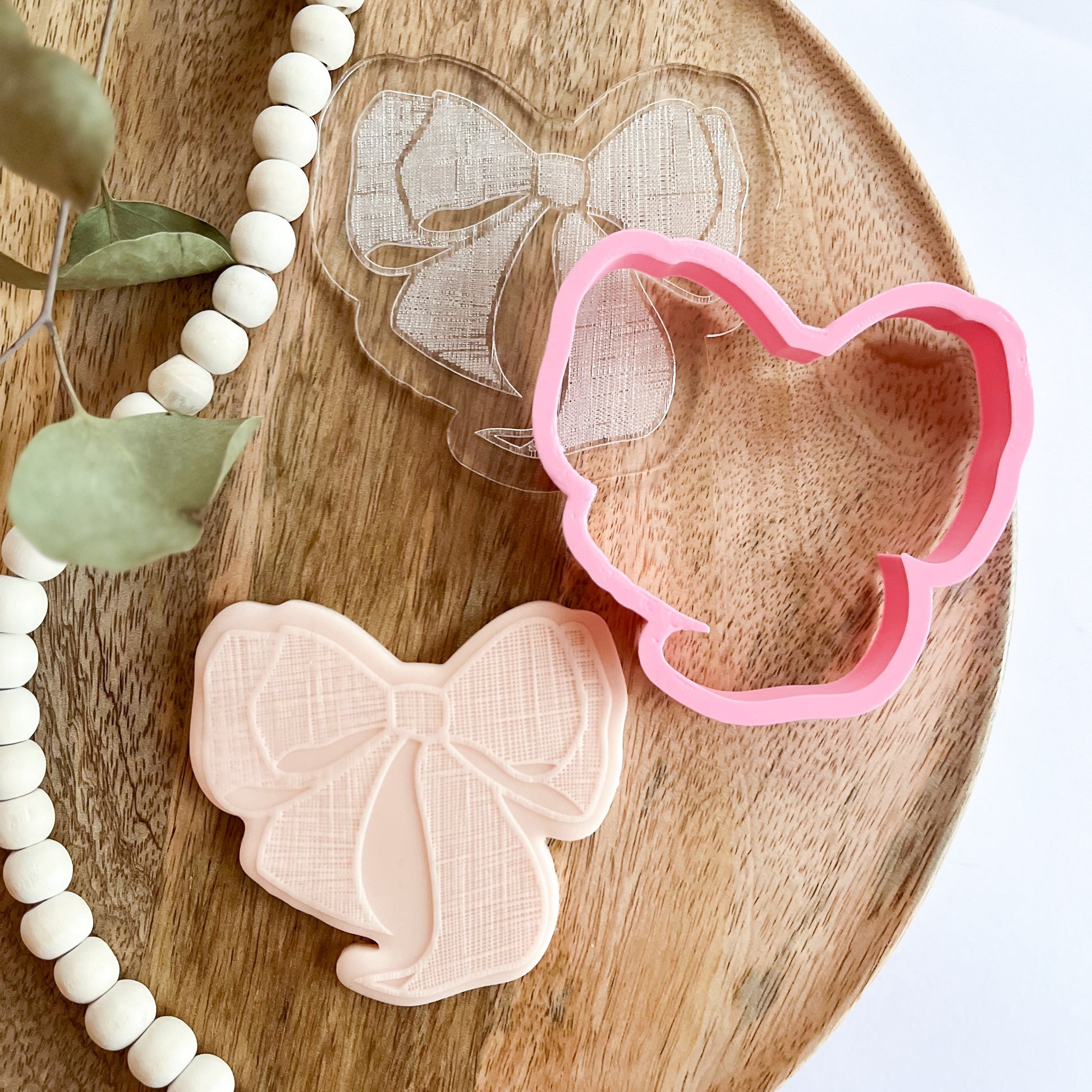 Textured bow cookie cutter and embosser for elegant baking and decorating cookies for gifts or parties.