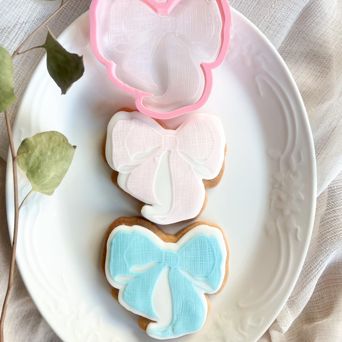 Textured bow cookie cutter and embosser for elegant baking and decorating cookies for gifts or parties.