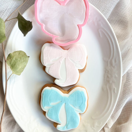 Textured bow cookie cutter and embosser for elegant baking and decorating cookies for gifts or parties.