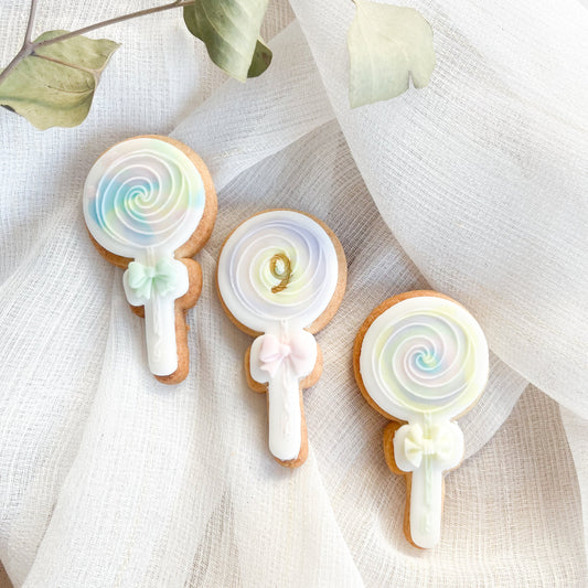 Lollipop-shaped cookie cutter and bow embosser, great for decorating cookies for birthday parties or candy-themed celebrations.