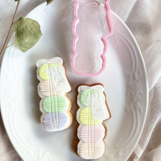 Macaron stack cookie cutter and embosser with “Love” tag, ideal for romantic cookie decorating or wedding treats.