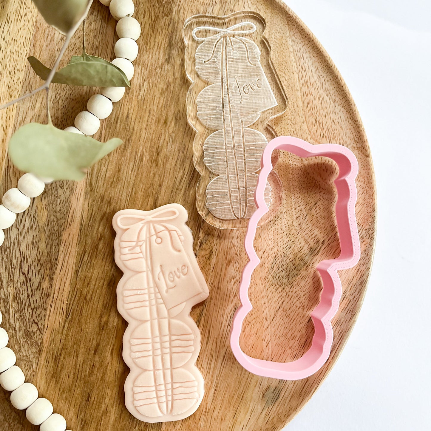 Macaron stack cookie cutter and embosser with “Love” tag, ideal for romantic cookie decorating or wedding treats.