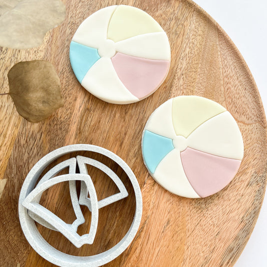 Decorative cookies with geometric patterns on a wooden board with a cookie cutter.