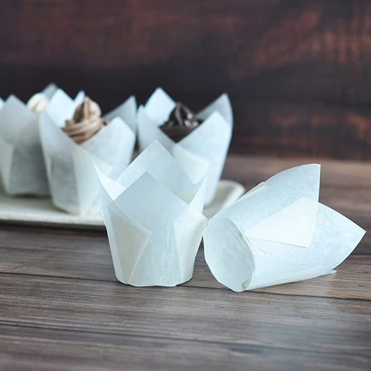 White paper tulip-shaped containers on a wooden surface with a blurred background.