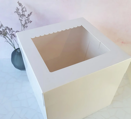 White cake box with a scalloped edge on a light background